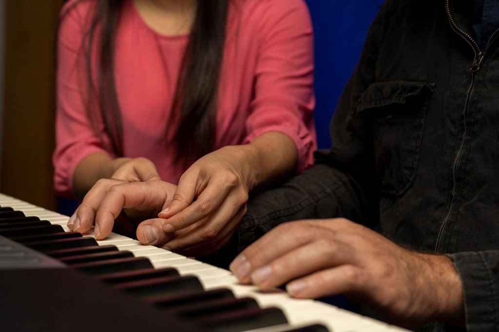 Professora ensinando seu aluno a tocar piano e gravar aula online