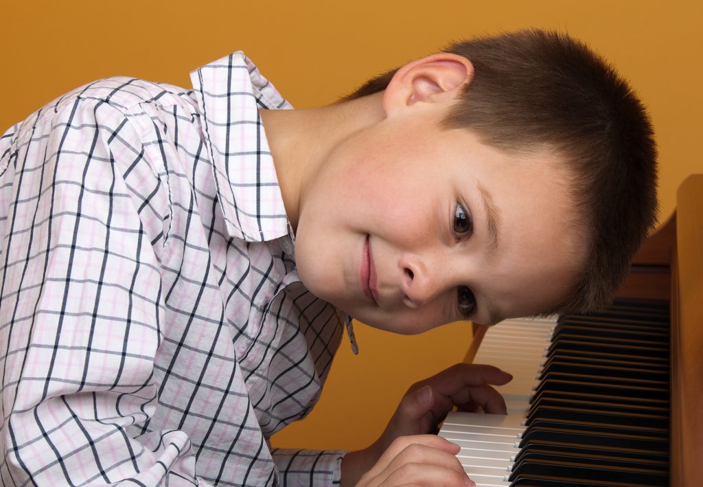 Criança tirando música de ouvido no piano